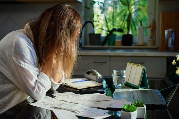 A person sitting at a desk, looking stressed while reviewing financial documents on a laptop. The image highlights the stress and burden of student loan debt.