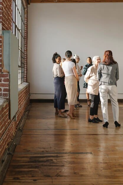 A photo showing a diverse group of people standing in line at a community center, waiting to receive information about government assistance programs. The scene is brightly lit and conveys a sense of hope and community support.