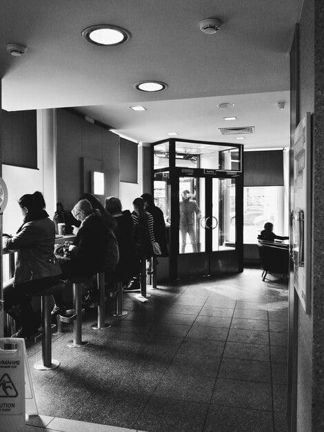 A split image. On one side, a crowded waiting room at a social services agency. On the other side, a person successfully submitting an online application with a smile. The image contrasts challenges with solutions.