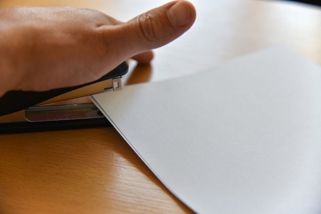 A person carefully filling out an application form with a pen, with a magnifying glass placed over the form to highlight the details.
