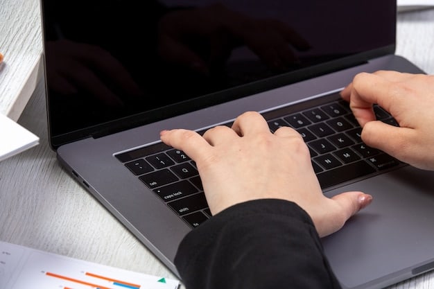 A close-up of hands typing on a laptop keyboard, with the focus on the screen displaying an unemployment benefits application form. The lighting is bright, emphasizing the digital nature of the process.